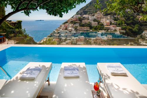 two beds in a pool with a view of a city at Villa Fiorentino in Positano