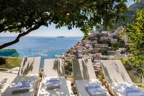 a group of chairs sitting on a hill with a view at Villa Fiorentino in Positano