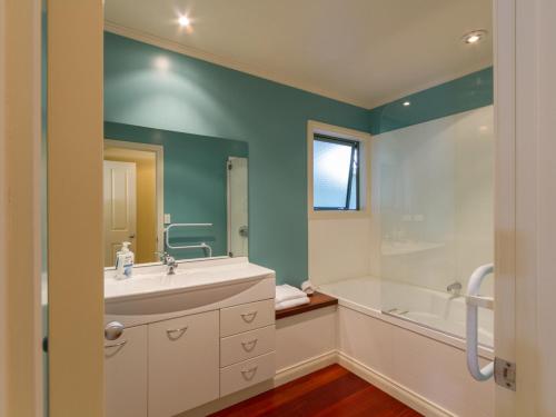 a bathroom with a sink and a tub and a shower at Sawmillers Retreat - Arrowtown Holiday Home in Arrowtown