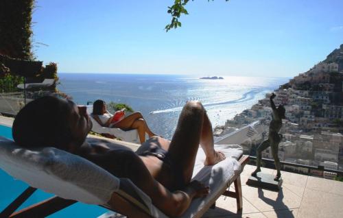a man and woman laying in chaise lounges at a resort at Villa Fiorentino in Positano
