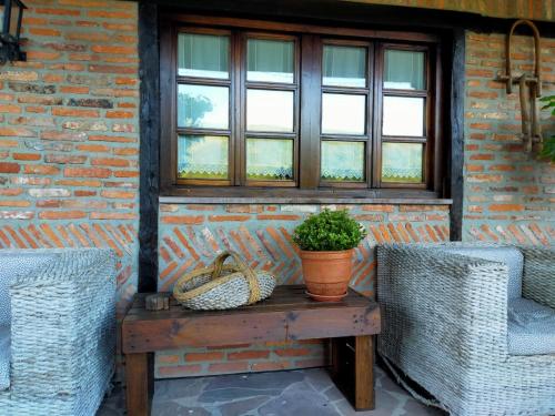 a table with two wicker chairs and a window at La Riguera De Ucieda in Ucieda de Arriba