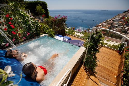 two people in a swimming pool on a balcony at Villa Fiorentino in Positano
