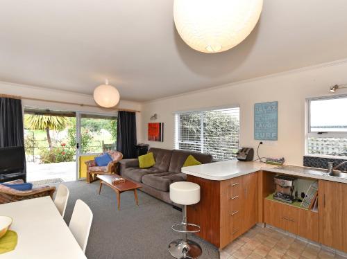 a kitchen and living room with a couch at Blue Lagoon - Kaiteriteri Holiday Unit in Kaiteriteri