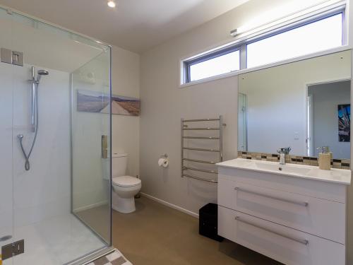 a bathroom with a shower and a sink and a toilet at Sunhaven Lakeside - Cromwell Holiday Home in Cromwell
