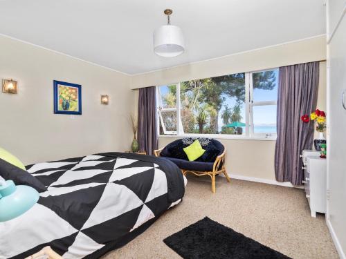 a bedroom with a black and white bed and a window at Lake Shores Cottage - Hannahs Bay Holiday Home in Rotokawa