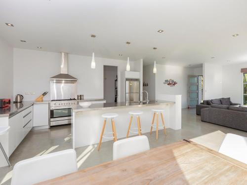 a kitchen and living room with a counter and stools at Paradise Haven - Omaha Holiday Home in Omaha