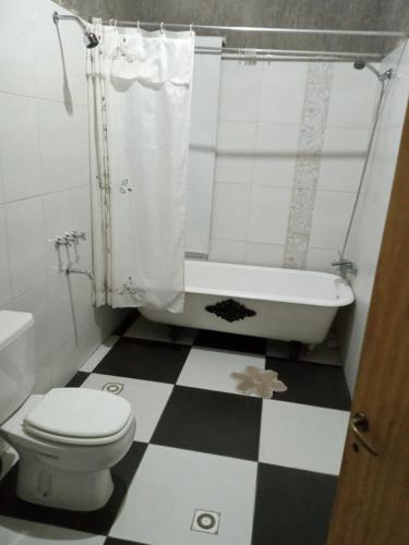 uma casa de banho com piso em xadrez preto e branco em Sueños de Amor em San Carlos