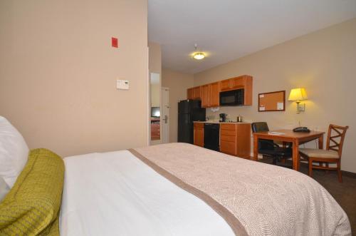 a bedroom with a bed and a kitchen with a table at Candlewood Suites Clarksville by IHG in Clarksville