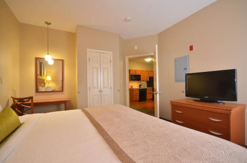 a bedroom with a bed and a flat screen tv at Candlewood Suites Clarksville by IHG in Clarksville