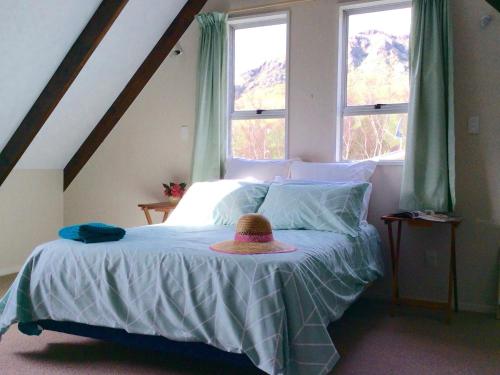 a bedroom with a bed with a hat on it at Shiloh - Diamond Harbour Accommodation in  Lyttelton