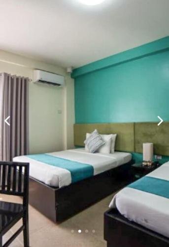 a room with two beds and a blue wall at Residencia Boracay in Boracay