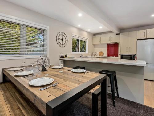 a large kitchen with a wooden table in a room at The Hillvue with Spa - Arrowtown Holiday Home in Arrowtown