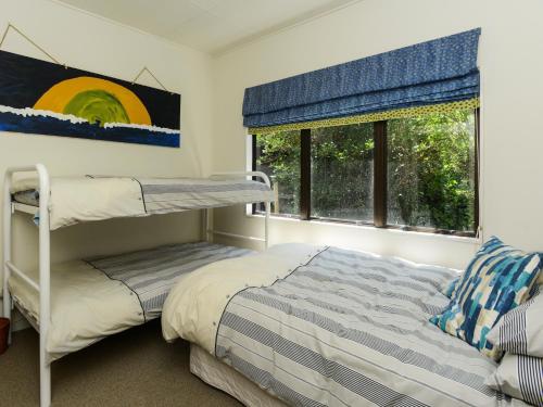 a bedroom with a bunk bed and a window at Bach 112 - Waimarama Holiday Home in Waimarama