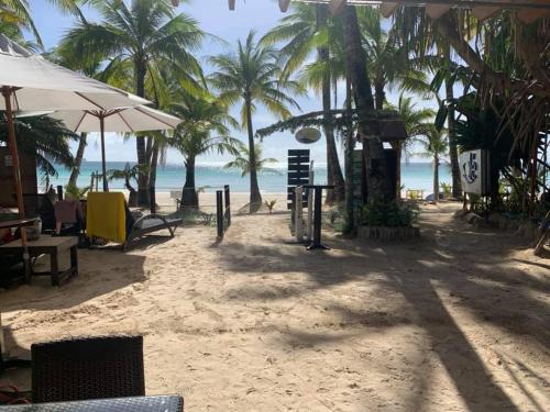 a sandy beach with palm trees and the ocean at Residencia Boracay in Boracay
