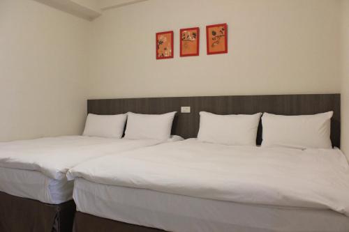 dos camas sentadas una al lado de la otra en una habitación en Sunnyside Hotel en Kaohsiung