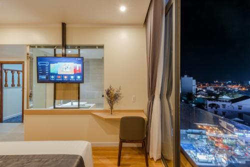 a room with a bed and a tv and a window at The Empire Hotel in Phu Quoc