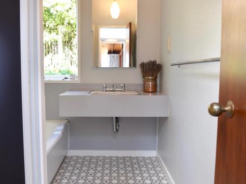 a bathroom with a sink and a mirror at Anchor in Akaroa - Akaroa Holiday Home in Akaroa