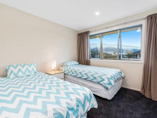 two beds in a room with a window at Pisa Oasis - Cromwell Holiday Home in Cromwell