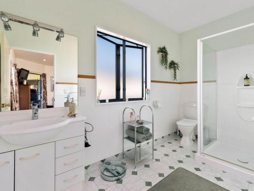 a bathroom with a sink and a shower and a toilet at Kawarau Bay View - Cromwell Holiday Home in Cromwell