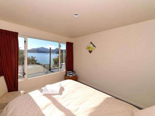 OhingaroaにあるNgaire's Haven - Mahau Sound Holiday Homeのベッドルーム1室(ベッド1台、大きな窓付)