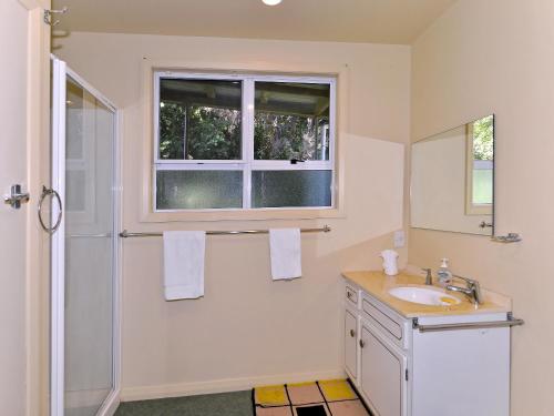 baño con lavabo y ventana en Ngaire's Haven - Mahau Sound Holiday Home, en Ohingaroa