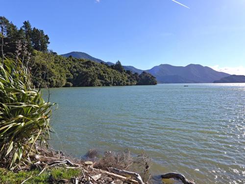 a large body of water with mountains in the background at Ngaire's Haven - Mahau Sound Holiday Home in Ohingaroa