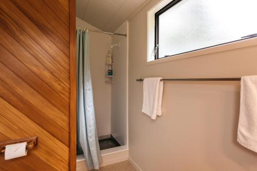 a bathroom with a shower and a window at Oneroa Oasis - Oneroa Holiday Home in Oneroa