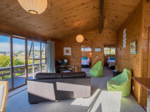 a living room with a couch and a table at Beach House on the Ridge - Kaiteriteri House in Kaiteriteri