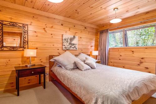 a bedroom with a bed in a log cabin at Lakeside Landing - Lake Tarawera Holiday Home in Lake Tarawera