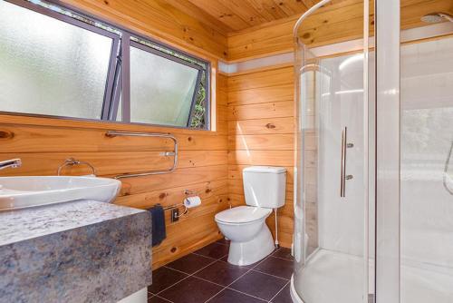 a bathroom with a toilet and a shower and a sink at Lakeside Landing - Lake Tarawera Holiday Home in Lake Tarawera