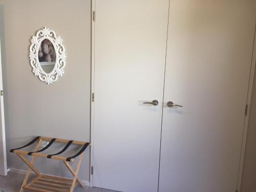 a white cabinet with a mirror and a chair at Kingsley Quarters in Cambridge
