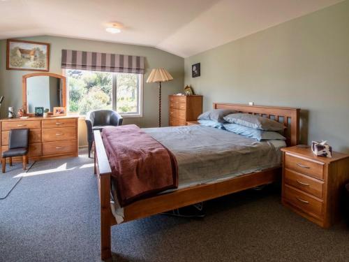a bedroom with a bed and a desk and a mirror at Bay Bliss - Akaroa Holiday Home in Akaroa