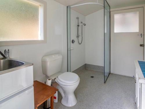a bathroom with a shower and a toilet and a sink at Bay Bliss - Akaroa Holiday Home in Akaroa