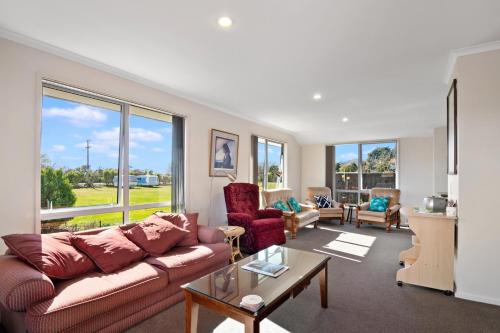 a living room with a couch and a table at Paradise in Pohara - Pohara Beach Holiday Home in Pohara