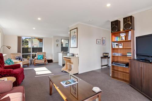 a living room with a couch and a tv at Paradise in Pohara - Pohara Beach Holiday Home in Pohara