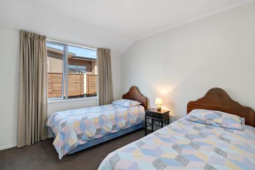 a bedroom with two beds and a window at Paradise in Pohara - Pohara Beach Holiday Home in Pohara