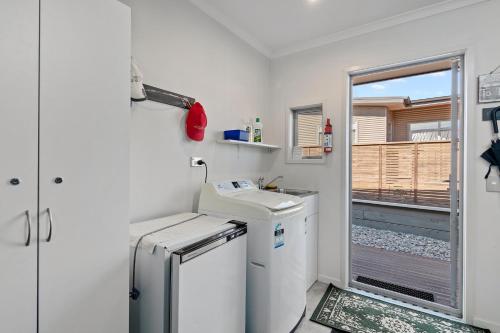 a small kitchen with a sink and a refrigerator at Paradise in Pohara - Pohara Beach Holiday Home in Pohara