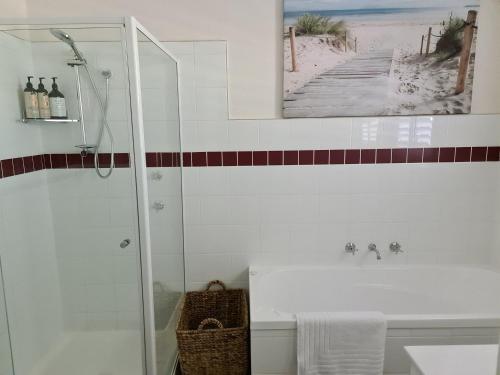 a bathroom with a shower and a sink at Harden Golfers Rest Accommodation in Harden