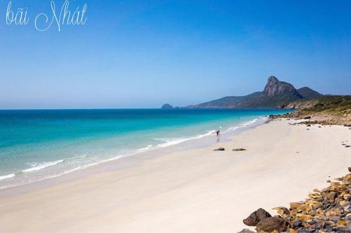 a person standing on a beach near the ocean at Hotel Hương Đào in Con Dao