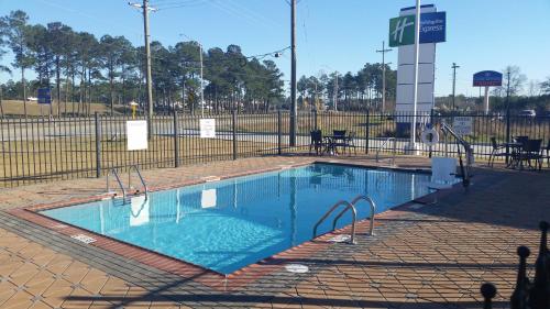 an empty swimming pool in front of a fence at Holiday Inn Express Slidell by IHG in Slidell