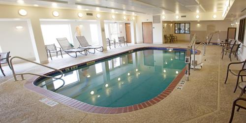 a pool in a hotel room with chairs and tables at Holiday Inn Express & Suites Yankton by IHG in Yankton
