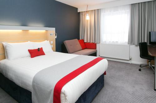 a hotel room with a large bed and a chair at Holiday Inn Express Antrim by IHG in Antrim