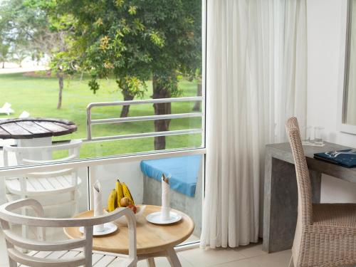 a room with a table and chairs and a window at Trinco Blu by Cinnamon in Trincomalee