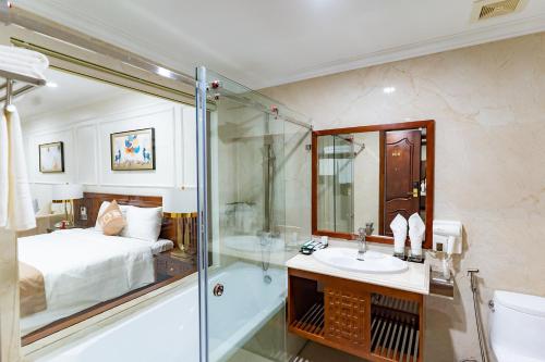 a bathroom with a bed and a shower and a sink at TỪ SƠN LUXURY 2 HOTEL in Ðại Dính