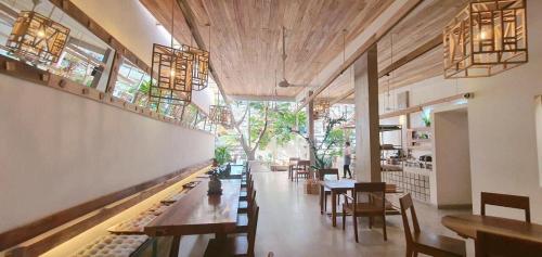 a restaurant with wooden tables and chairs and windows at Hotel Hương Đào in Con Dao