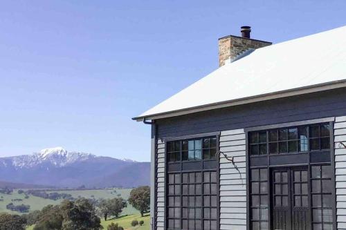 a barn with a mountain in the background at Coombs Hill Barn in Merrijig