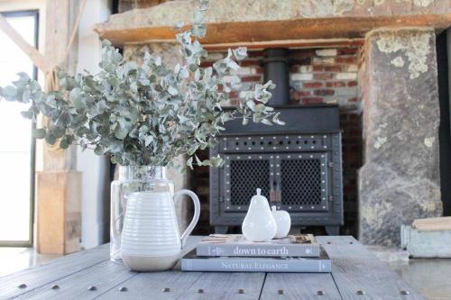 a vase with flowers in it on a table at Coombs Hill Barn in Merrijig