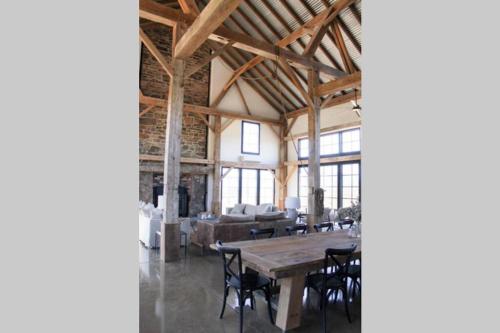 a large room with a wooden table and chairs at Coombs Hill Barn in Merrijig
