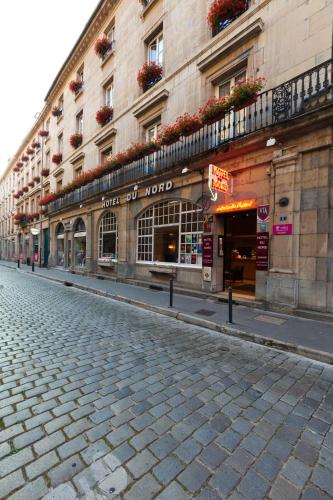 a cobblestone street in front of a building at Hotel Du Nord in Besançon