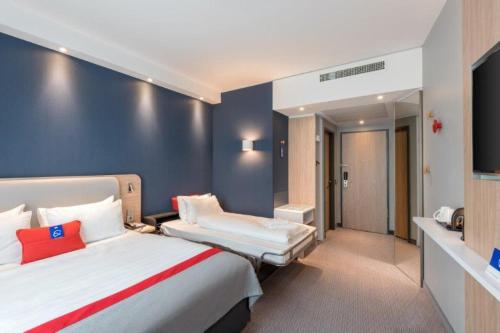 a hotel room with two beds and a television at Holiday Inn Express - Sindelfingen by IHG in Sindelfingen
